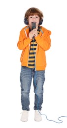 Little boy with microphone and headphones singing on white background