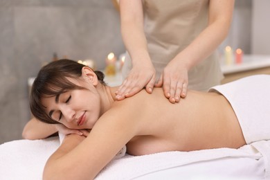 Young woman receiving back massage in spa salon