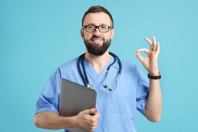 Photo of Doctor with laptop showing okay gesture on light blue background