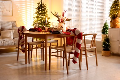 Photo of Christmas table setting with stylish dishware and festive decor indoors