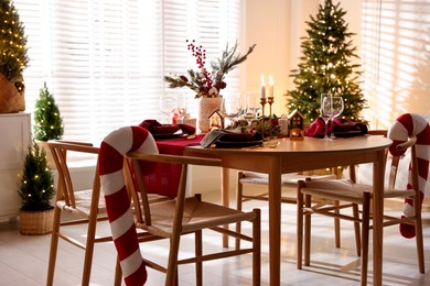 Photo of Christmas table setting with stylish dishware and festive decor indoors