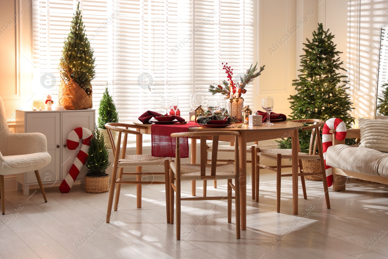 Photo of Christmas table setting with stylish dishware and festive decor indoors