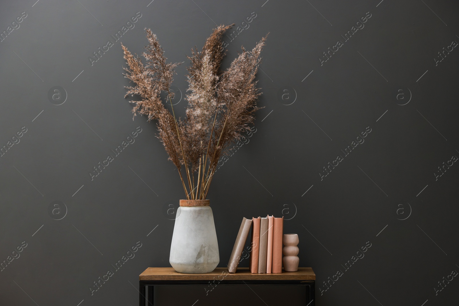 Photo of Console table with decor near grey wall in room. Interior design