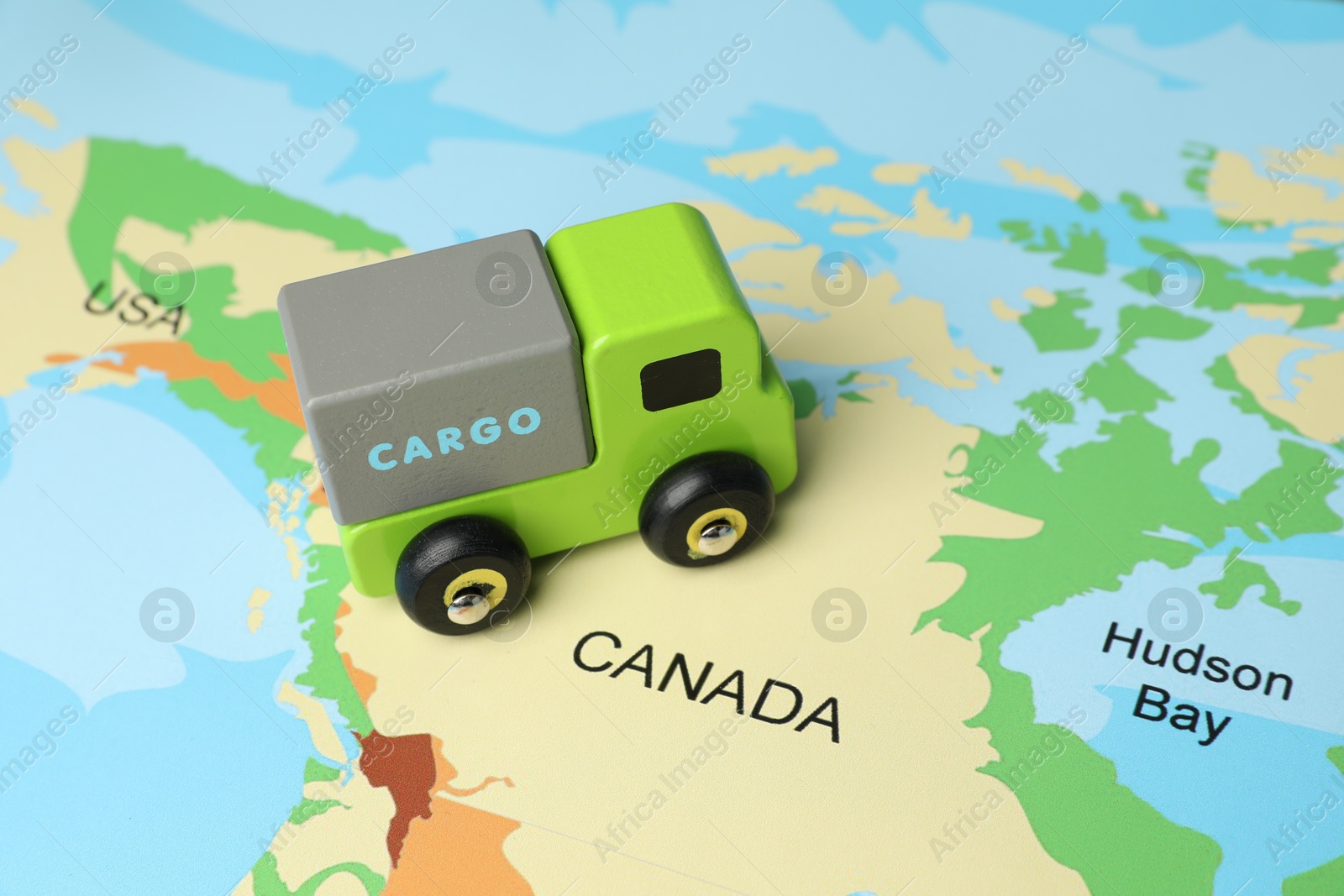 Photo of Toy truck on world map, closeup. Logistics concept