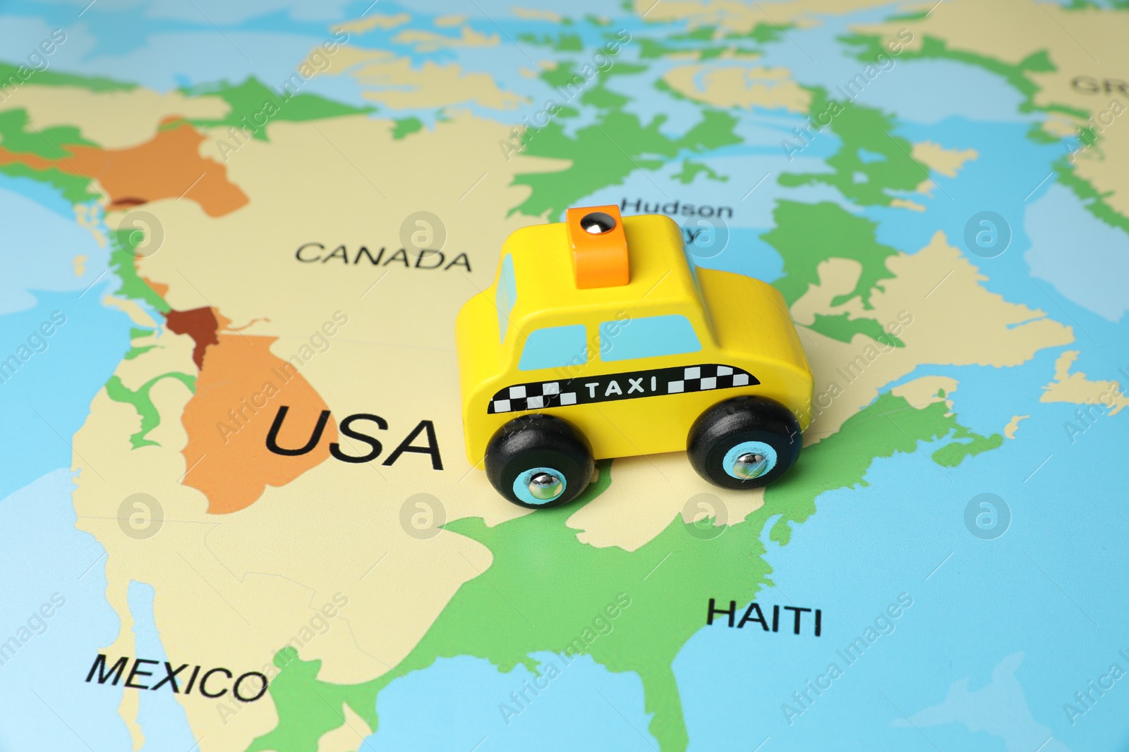 Photo of Yellow taxi car on world map, closeup