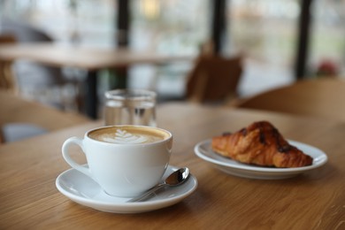 Photo of Delicious breakfast served on wooden table in cafe, closeup