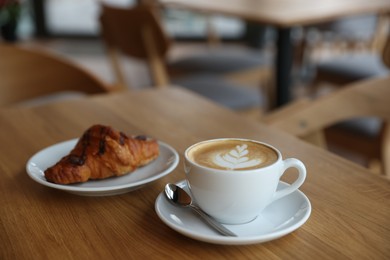 Photo of Delicious breakfast served on wooden table in cafe, closeup