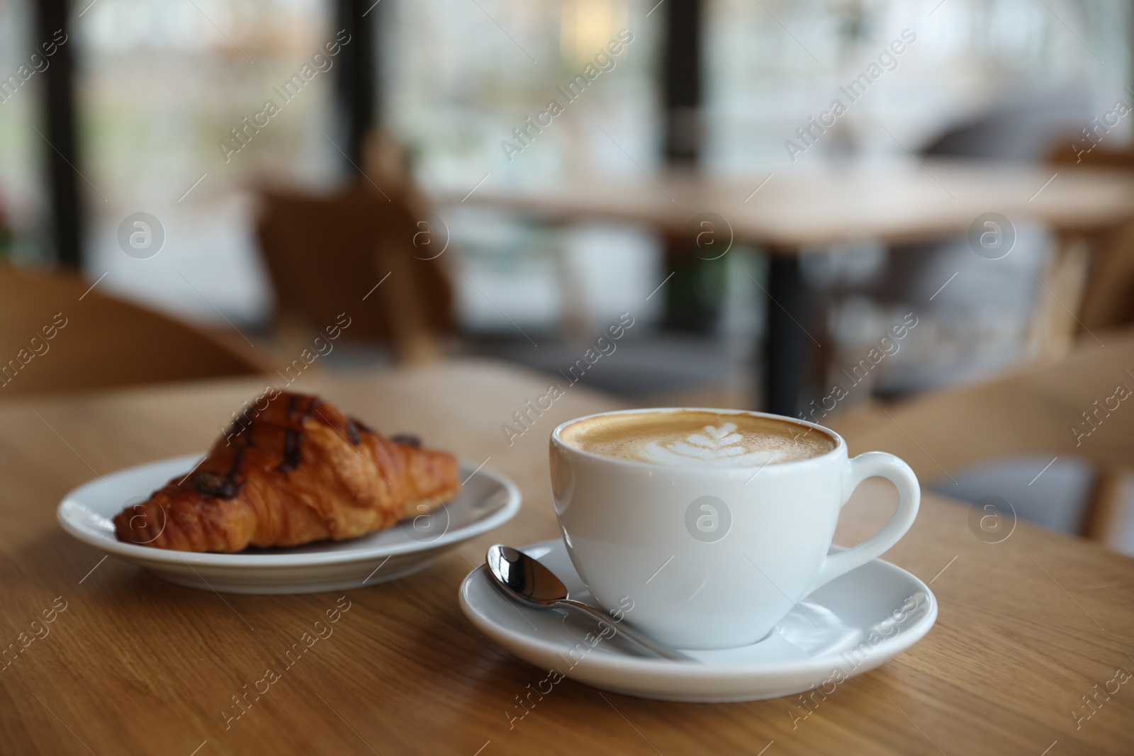 Photo of Delicious breakfast served on wooden table in cafe, closeup