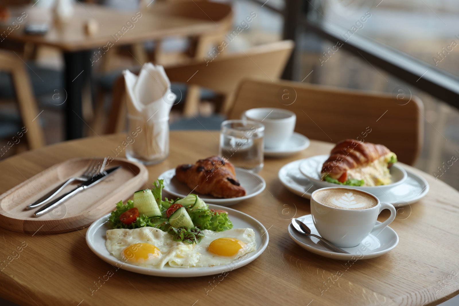 Photo of Delicious breakfast served on wooden table in cafe