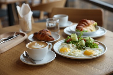 Photo of Delicious breakfast served on wooden table in cafe