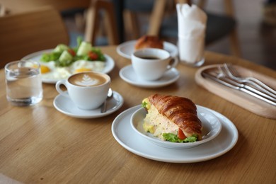 Photo of Delicious breakfast served on wooden table in cafe