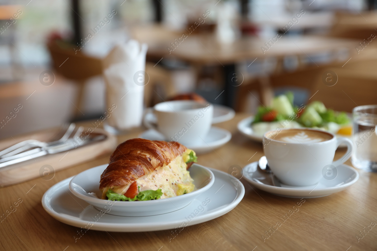 Photo of Delicious breakfast served on wooden table in cafe