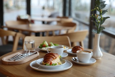 Photo of Delicious breakfast served on wooden table in cafe