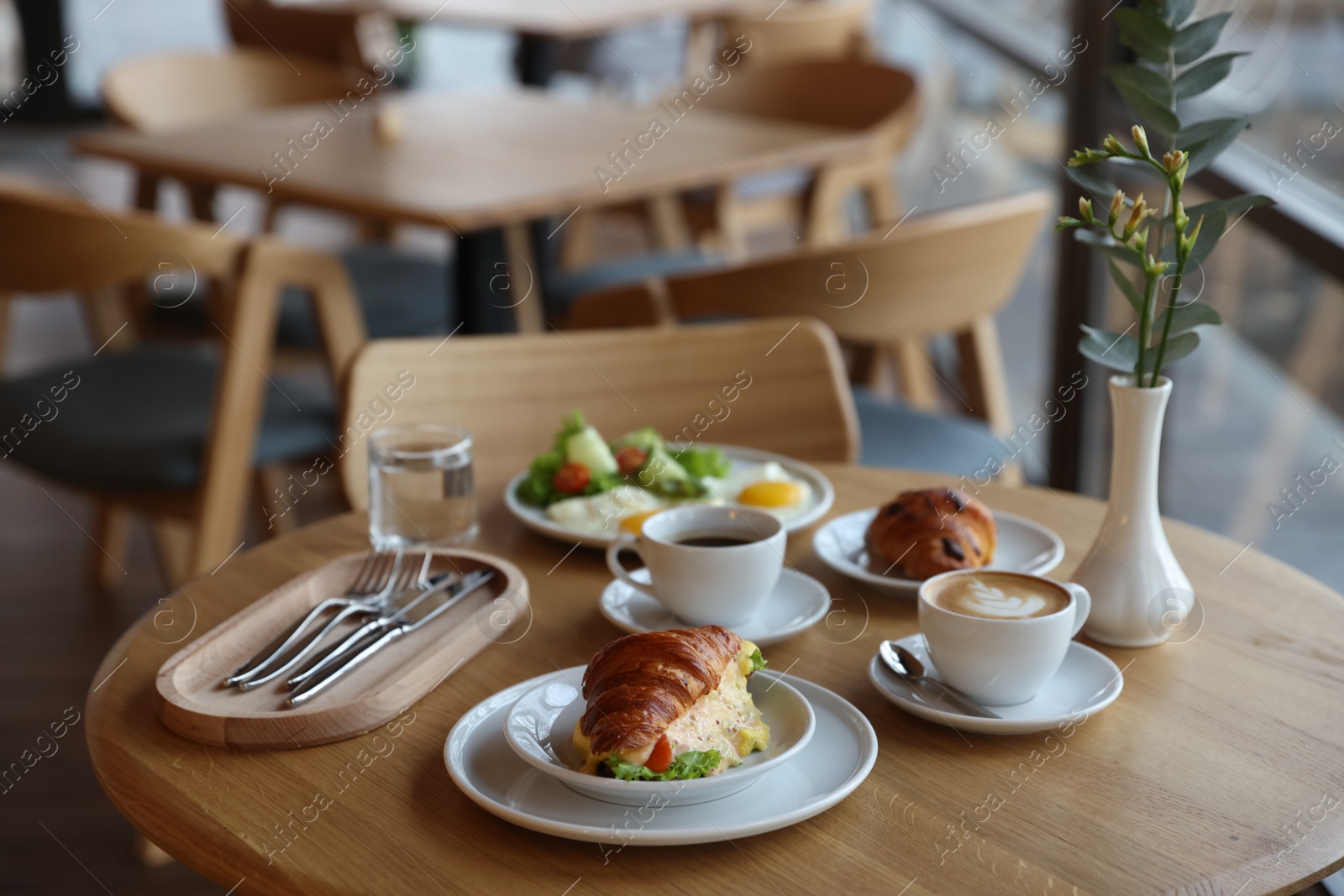 Photo of Delicious breakfast served on wooden table in cafe