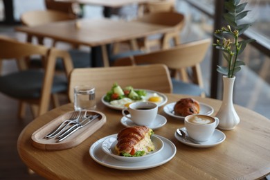 Photo of Delicious breakfast served on wooden table in cafe