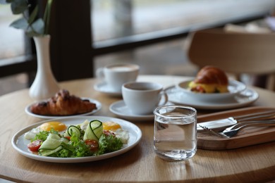 Photo of Delicious breakfast served on wooden table in cafe