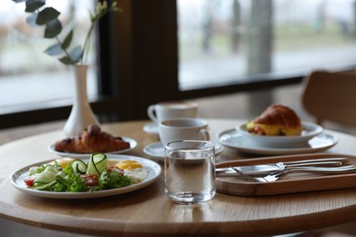 Photo of Delicious breakfast served on wooden table in cafe