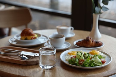 Photo of Delicious breakfast served on wooden table in cafe