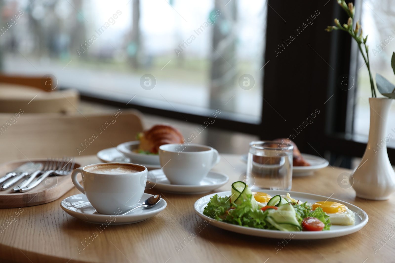 Photo of Delicious breakfast served on wooden table in cafe