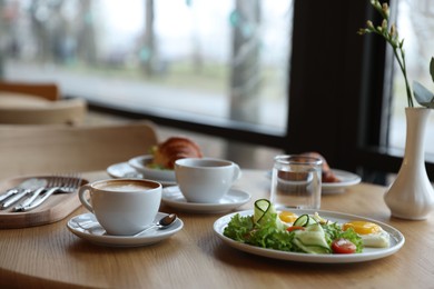 Photo of Delicious breakfast served on wooden table in cafe