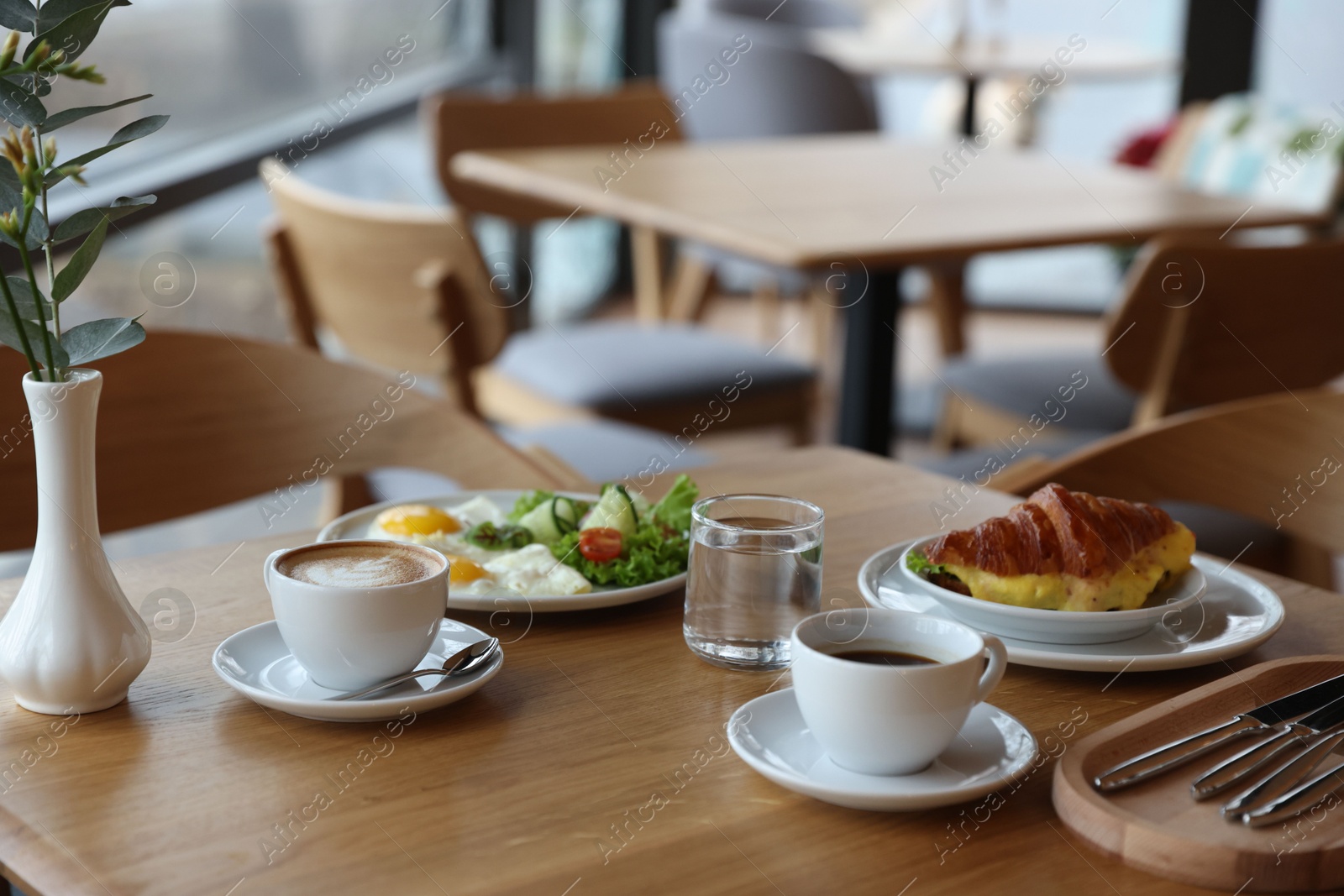 Photo of Delicious breakfast served on wooden table in cafe