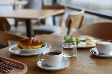 Photo of Delicious breakfast served on wooden table in cafe