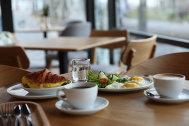 Photo of Delicious breakfast served on wooden table in cafe