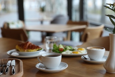 Photo of Delicious breakfast served on wooden table in cafe