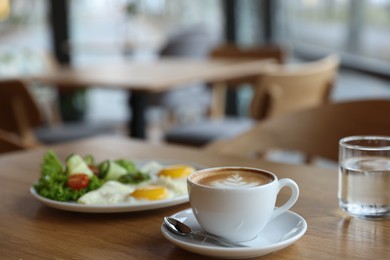 Photo of Delicious breakfast served on wooden table in cafe