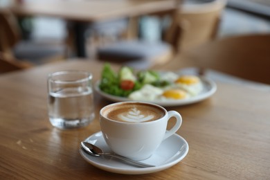 Photo of Delicious breakfast served on wooden table in cafe