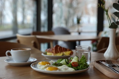 Photo of Delicious breakfast served on wooden table in cafe