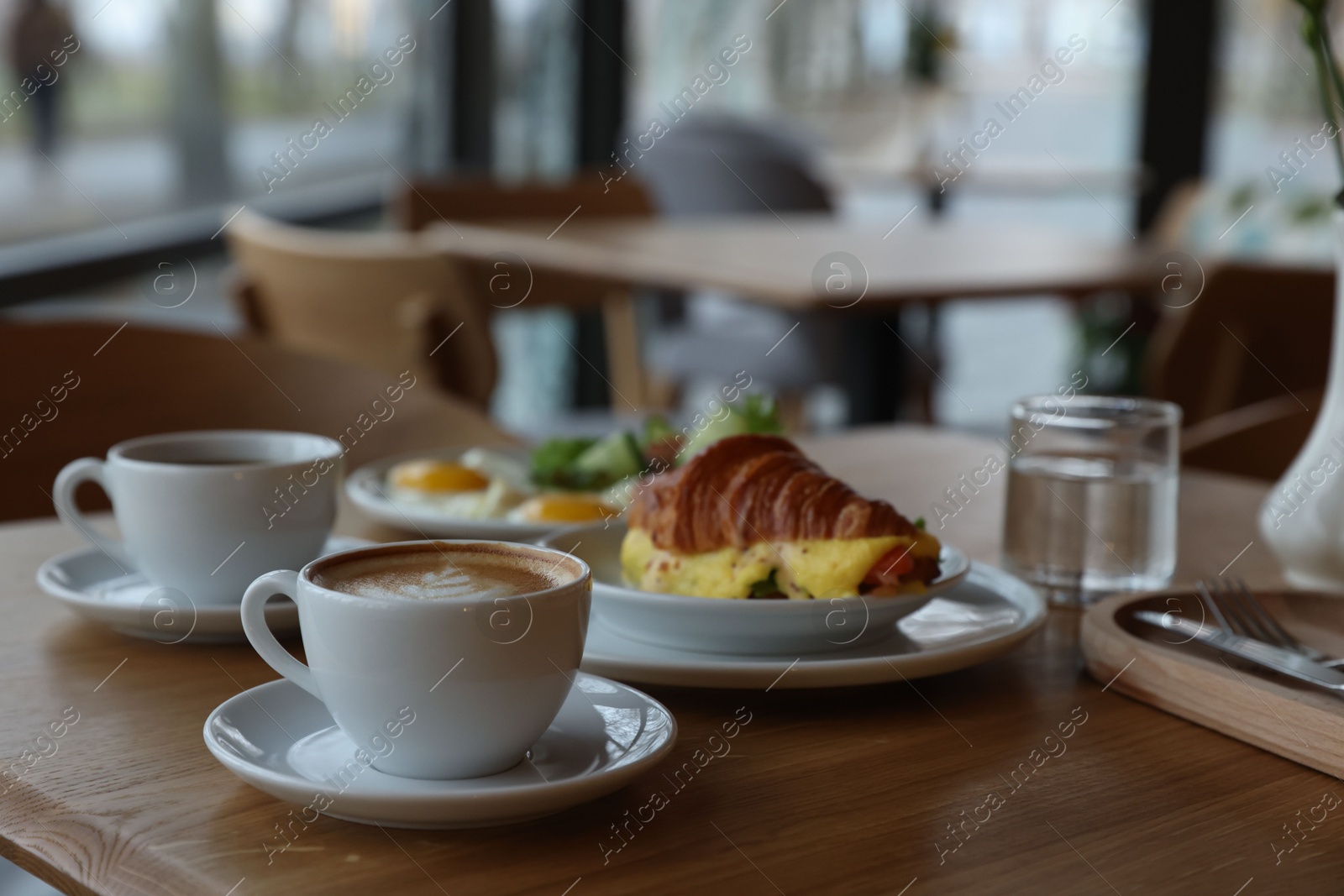 Photo of Delicious breakfast served on wooden table in cafe