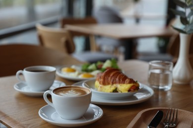 Photo of Delicious breakfast served on wooden table in cafe