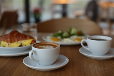 Photo of Delicious breakfast served on wooden table in cafe