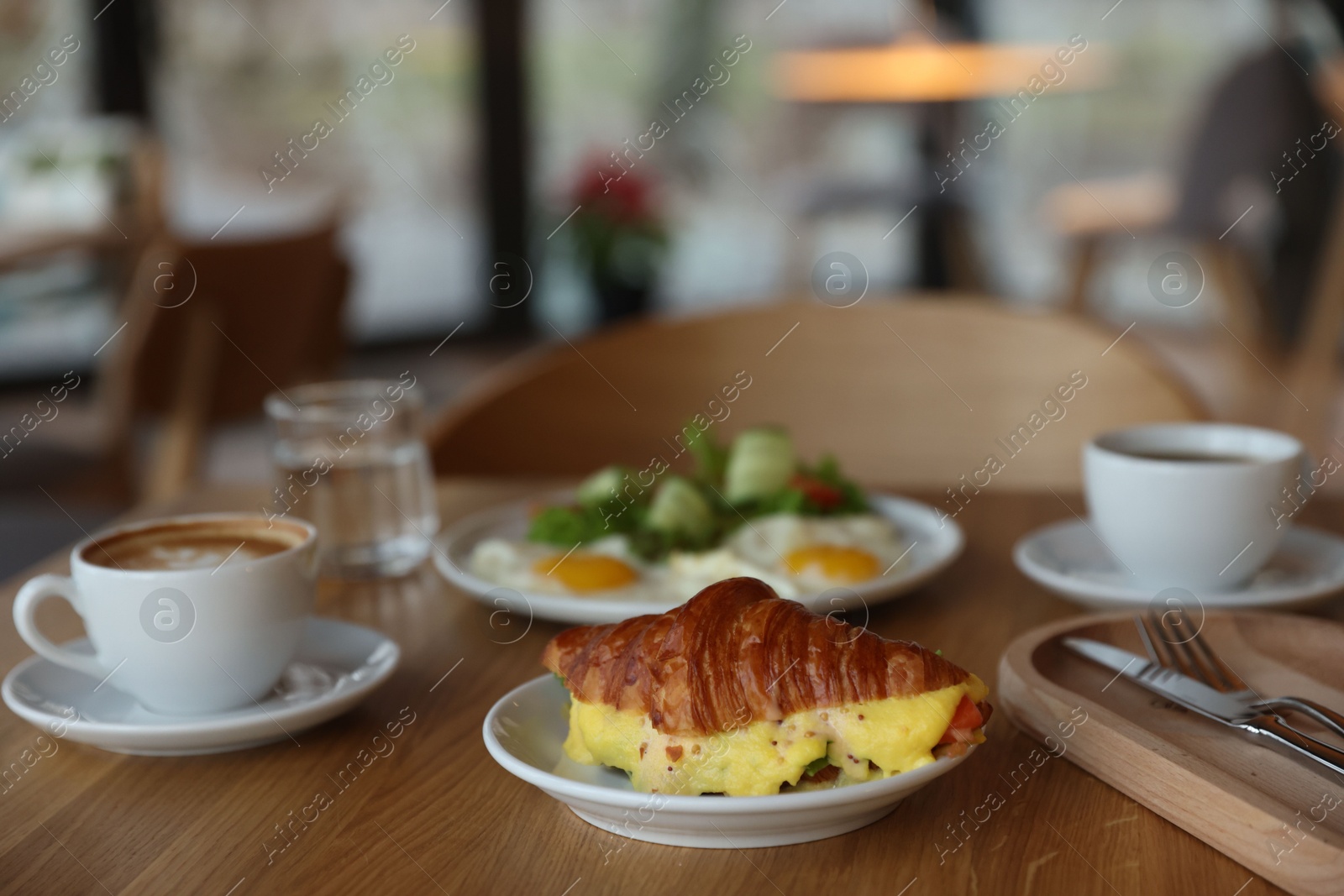 Photo of Delicious breakfast served on wooden table in cafe