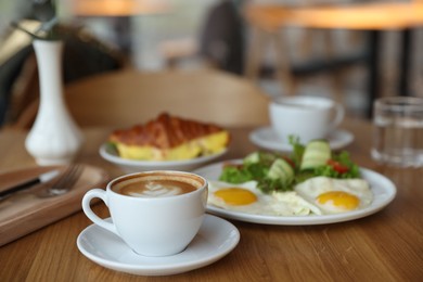 Photo of Delicious breakfast served on wooden table in cafe