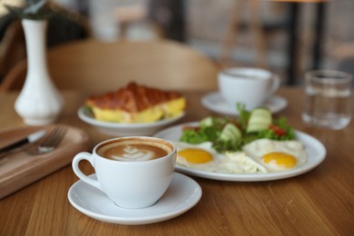 Photo of Delicious breakfast served on wooden table in cafe