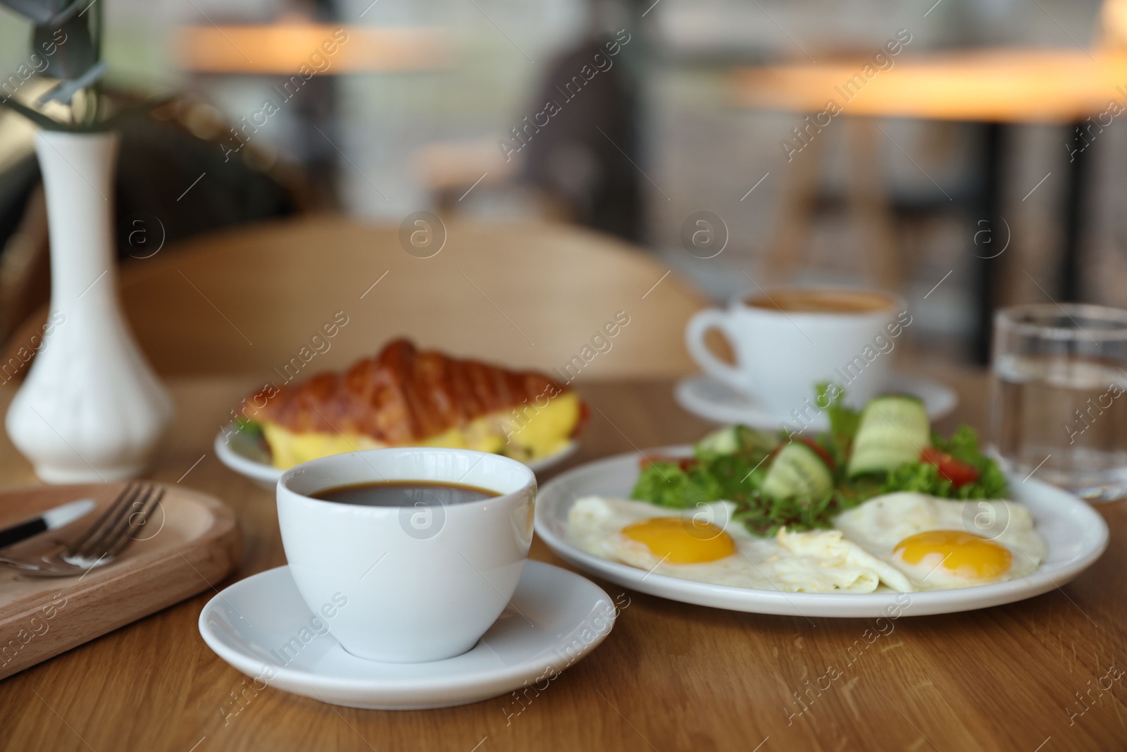 Photo of Delicious breakfast served on wooden table in cafe