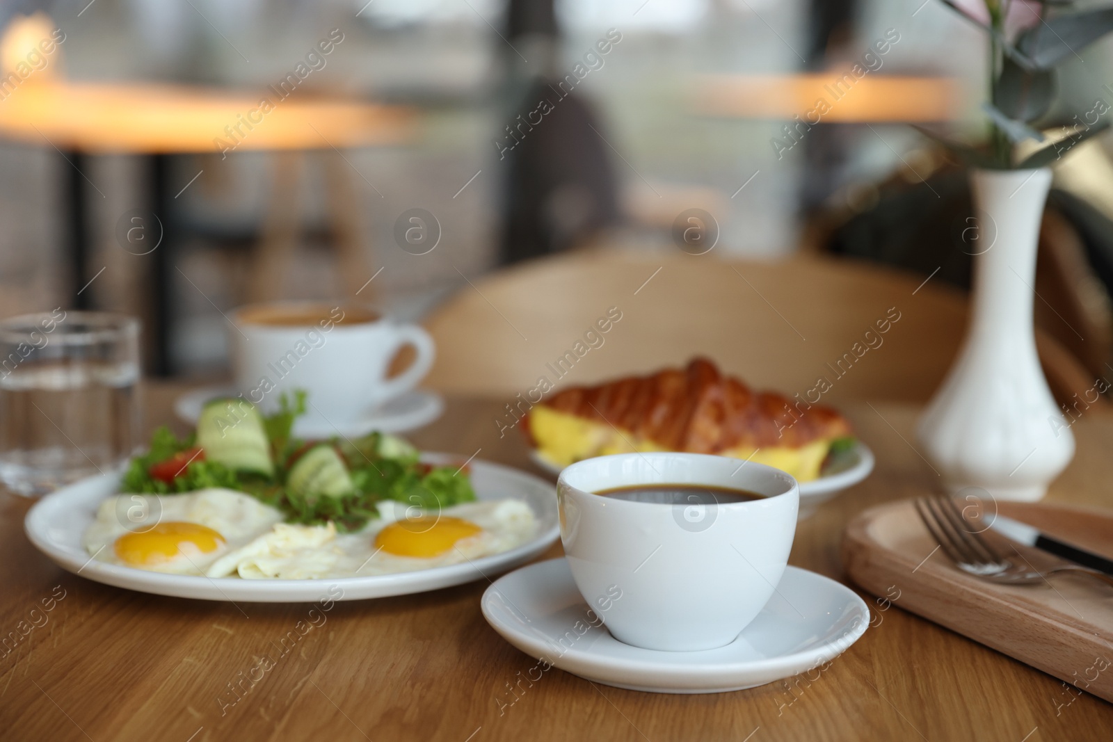 Photo of Delicious breakfast served on wooden table in cafe