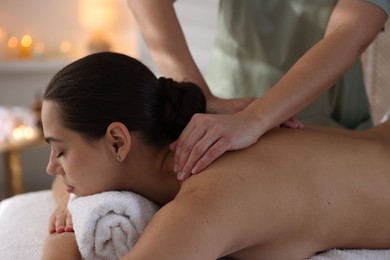 Photo of Young woman receiving massage in spa salon