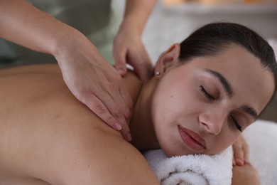 Photo of Young woman receiving massage in spa salon