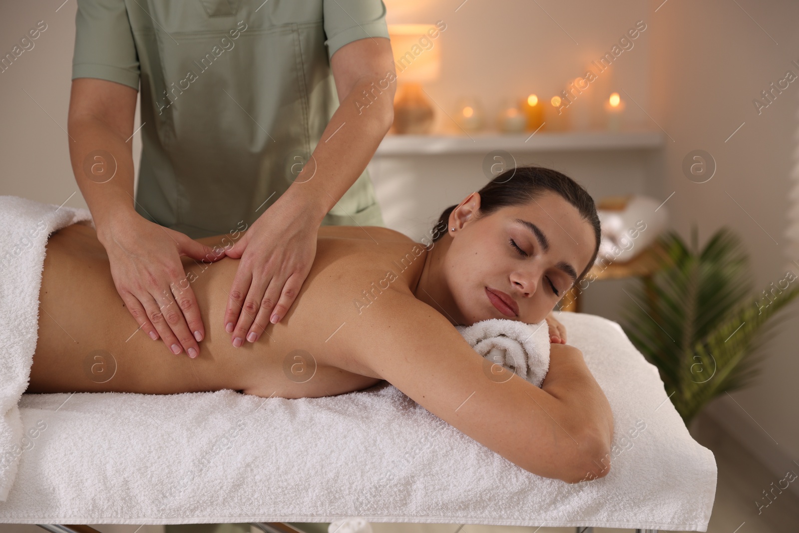 Photo of Young woman receiving massage in spa salon