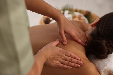 Photo of Woman receiving massage in spa salon, closeup