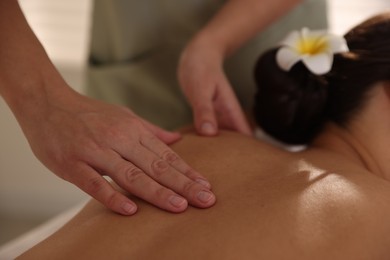 Woman receiving back massage in spa salon, closeup