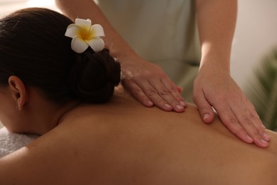 Photo of Woman receiving back massage in spa salon, closeup