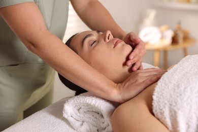 Photo of Young woman receiving massage in spa salon