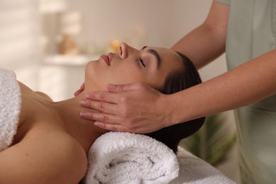 Photo of Young woman receiving massage in spa salon