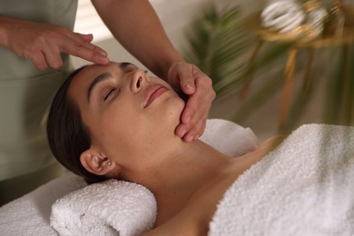 Photo of Woman receiving face massage in spa salon