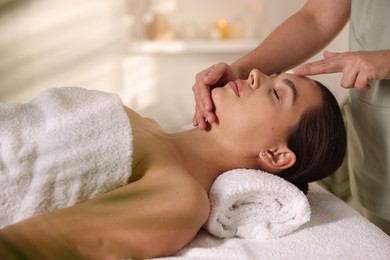 Photo of Woman receiving face massage in spa salon