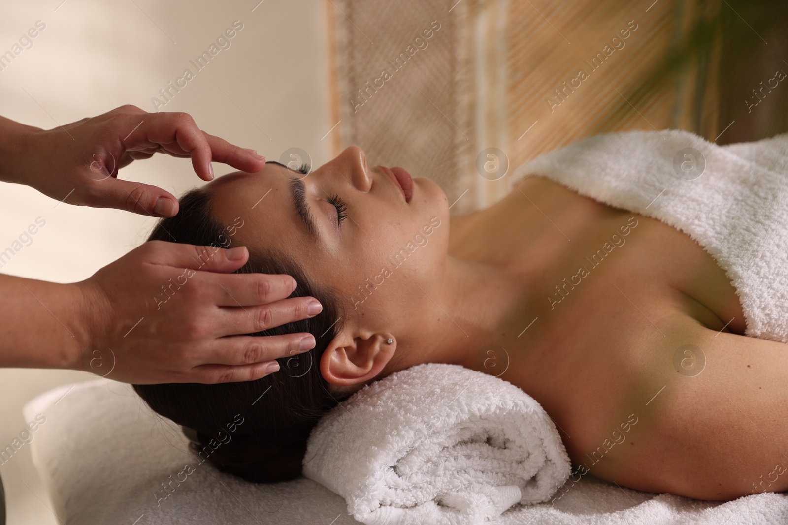 Photo of Woman receiving face massage in spa salon